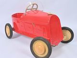 a red toy car that is sitting on a white surface