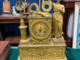 a gold clock sitting on a green table cloth