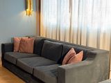 a living room with a couch, chair, and ottoman