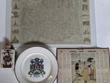 a plate with a coat of arms on it next to a plate with a picture on it