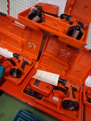 une boîte à outils orange contenant des outils, posée sur une table