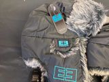 a bag with a fur hat and a cell phone in it