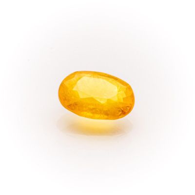a yellow sapphire stone on a white background