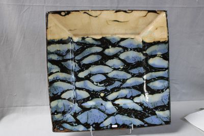 a blue and black plate sitting on a white table