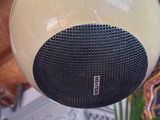a white and black speaker that is hanging from the ceiling