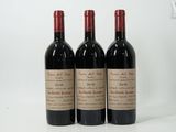 trois bouteilles de vin rouge posées sur une table blanche