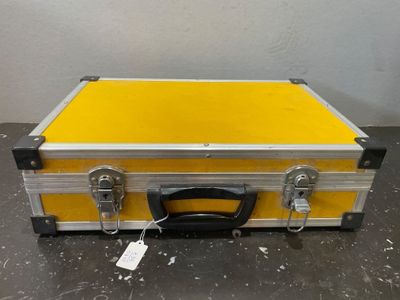 une vieille valise jaune et argent posée sur une table