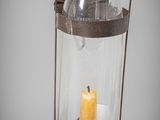 a glass lantern with a lit candle inside of it