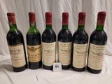 six bottles of red wine are lined up on a table