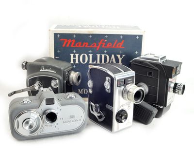 Trois appareils photo à l'ancienne sont posés à côté d'une boîte de cadeaux de Noël
