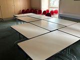 une pièce avec des tables et des chaises, et un tableau accroché au mur