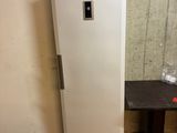 un réfrigérateur blanc posé à côté d'une table dans une pièce