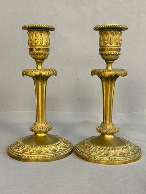 pair of antique brass candlesticks on a white background