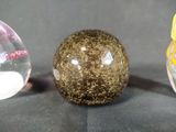 three glass balls sitting next to each other on a table