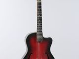 a red and black guitar hanging from a string on a white wall