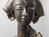statue of a woman with a hat on her head in a room