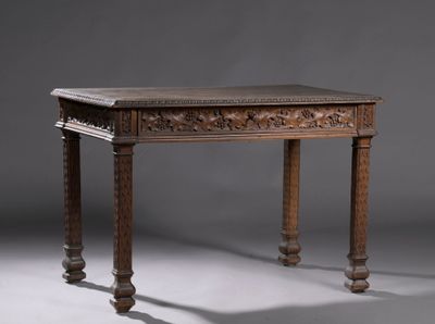 une vieille table en bois dont le plateau et les pieds sont sculptés