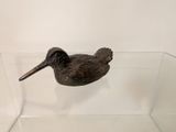 statue of a bird in a glass display case on a white wall