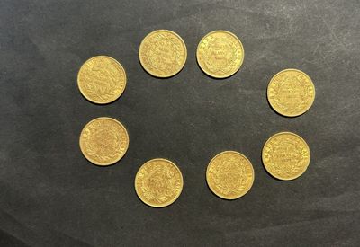 six pièces d'or disposées en cercle sur une surface noire
