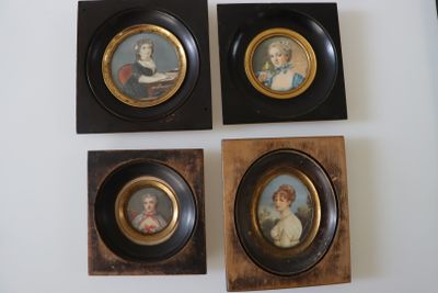 four framed miniature portraits of women and children are displayed on a wall
