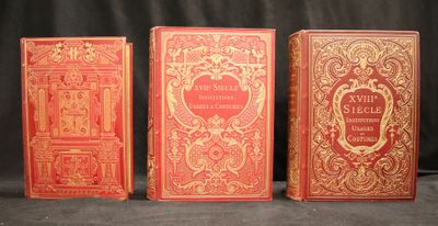 trois livres rouges posés les uns à côté des autres sur une table
