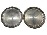 paire de plats anciens en métal argenté sur un socle, sur fond blanc