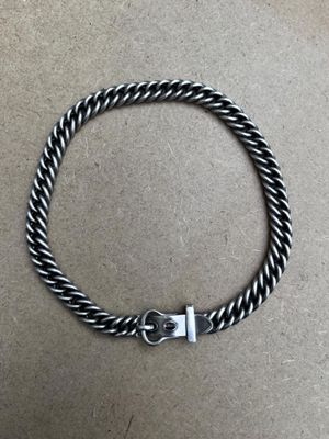 un bracelet tressé noir et blanc muni d'un fermoir en argent