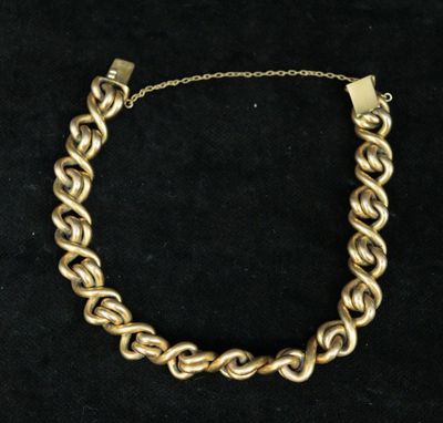 a gold chain bracelet on a black background