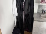 a closet with clothes hanging on a rail in the corner of the room