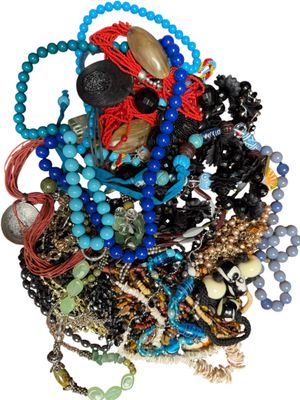 un tas de perles et de colliers de toutes sortes posés sur une surface blanche