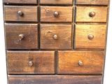 a wooden chest of drawers with many drawers on it