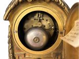 a gold clock with a bell on top of it