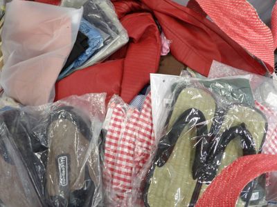 many pairs of shoes in bags on a table