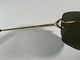sunglasses on a white surface with a black lens and a gold handle