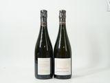 deux bouteilles de vin posées l'une à côté de l'autre sur une surface blanche
