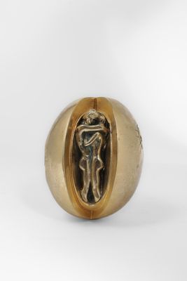 un gros plan d'une bague en or renfermant une statuette