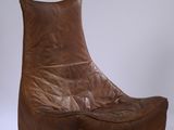 fauteuil en cuir marron posé sur une surface blanche, sur fond blanc