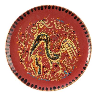 une assiette rouge sur laquelle est représenté un oiseau
