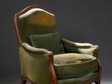 une vieille chaise avec un coussin rembourré vert et une structure en bois