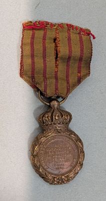 une médaille entourée d'un ruban, posée sur un fond blanc