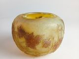 a yellow and brown vase sitting on a white surface