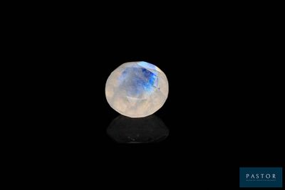 a white moons stone on a black surface in the dark