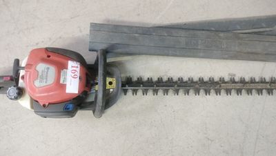 a close up of a hedger and a saw on the ground