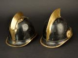 pair of black and gold fire helmets on a black background