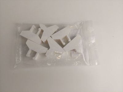 un sac contenant des figurines en plastique blanc posé sur une table