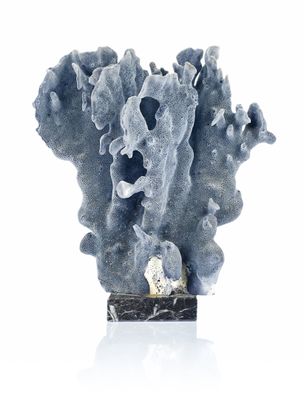 a blue coral with a rock in it on a white surface