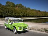 une jeep verte garée sur le bord de la route, près de l'eau