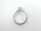 a ring with a diamond on it on a white surface