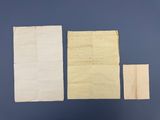 trois feuilles de papier et une feuille de papier posée sur une surface bleue