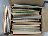 a cardboard box full of old records on the floor